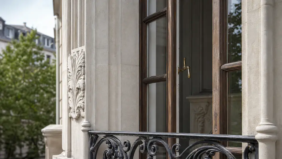 Detail von historischem Fenster, Schmiedeeisen und Steinmetzarbeit.