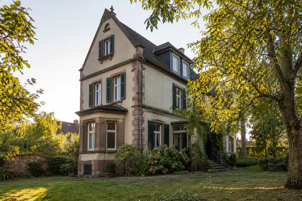 Historisches Familienhaus im warmen Abendlicht, würdevoll und unbesetzt.