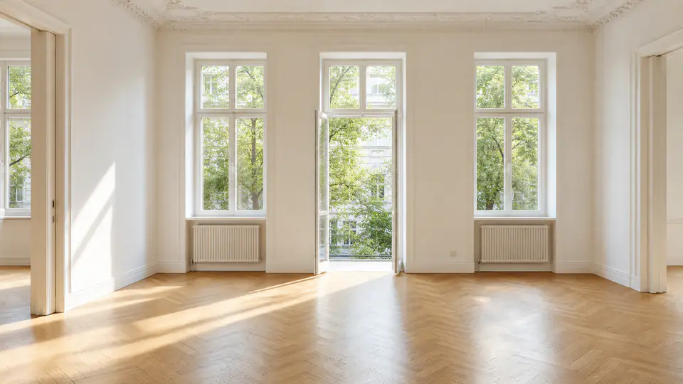 Derselbe Wertgedanke als leerer, sonniger Raum mit Parkett und Architekturdetail.
