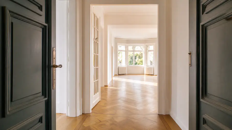 Offene Wohnungstür mit einladendem, leerem Flur und natürlichem Licht.